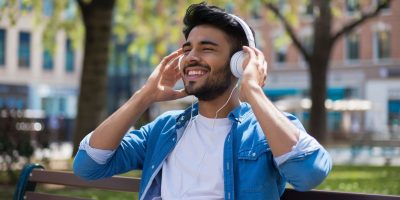 man-wearing-blue-jacket-is-smiling-while-listening-music-2